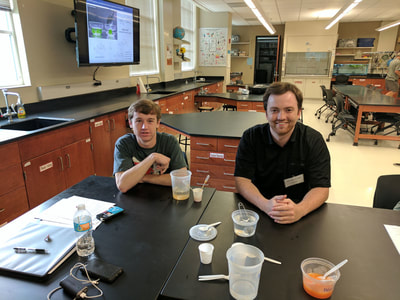 Two students sit at a table in the classroom / lab combination that was used for the event.